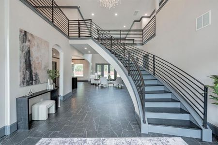 Elegant entrance and Stairway showing the beautiful tile and iron railings with steps enhanced by wood flooring