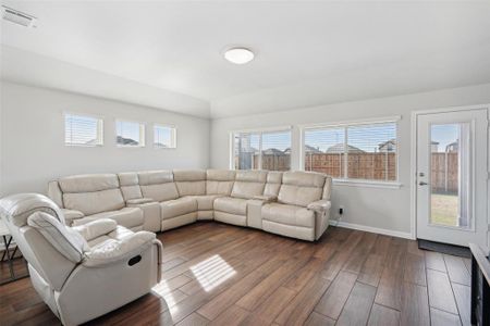 Living room with dark hardwood / wood-style flooring and a wealth of natural light