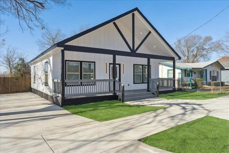 View of front of property featuring covered porch, fence, a front lawn, and concrete driveway