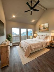 Bedroom featuring ceiling fan, dark hardwood / wood-style flooring, and vaulted ceiling with beams