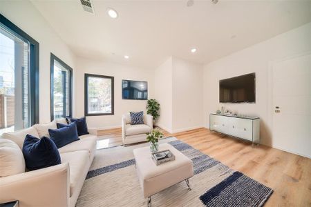 Living room featuring light wood-type flooring and plenty of natural light