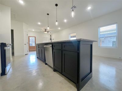 Kitchen featuring dishwasher, stove, a kitchen island with sink, and ceiling fan