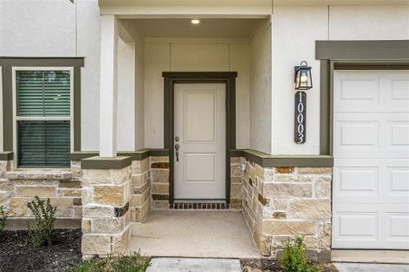 Step up to the inviting front porch of this stunning home. The elegant stone accents and modern lighting create a warm and welcoming entryway. This charming space is perfect for greeting guests and adds to the overall curb appeal of this beautiful property. Photos are from another Rylan floor plan.