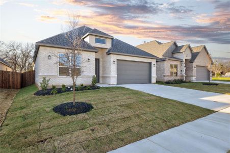 View of front facade featuring a yard and a garage