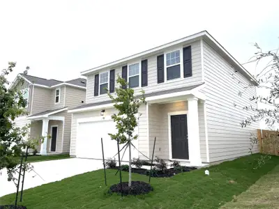 Traditional-style house with driveway, a front lawn, and a garage