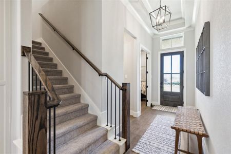 Entrance foyer featuring dark hardwood / wood-style flooring, a high ceiling, and an inviting chandelier