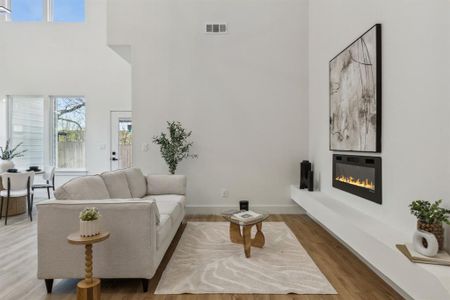 Living room featuring wood-type flooring and a high ceiling