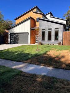 Contemporary home featuring a front lawn and a garage