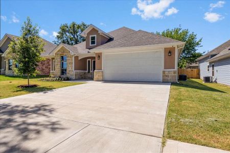 View of front of property with cooling unit, a garage, and a front yard