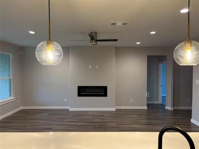 Unfurnished living room with ceiling fan and dark hardwood / wood-style floors