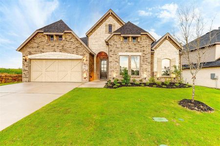 French country style house with a garage and a front lawn