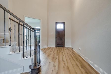 Foyer featuring a high ceiling and light hardwood / wood-style floors