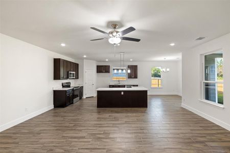 Kitchen featuring hardwood / wood-style flooring, stainless steel appliances, sink, and a center island