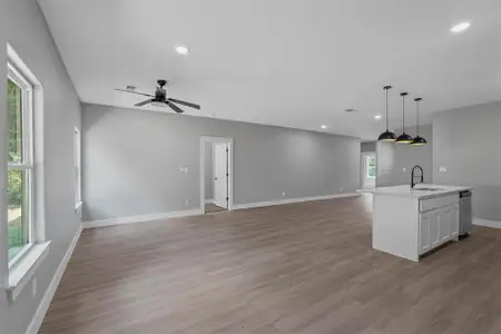 Kitchen featuring light wood-type flooring, an island with sink, sink, and ceiling fan