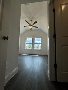 Additional living space with ceiling fan, dark hardwood / wood-style flooring, and lofted ceiling