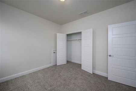 Unfurnished bedroom with a closet and carpet floors