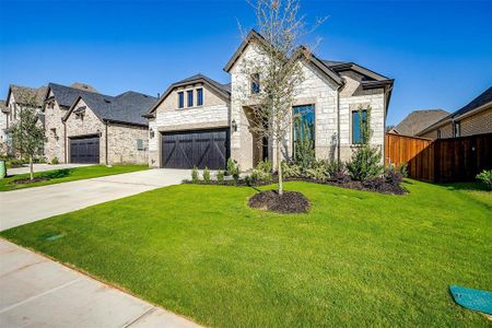 French country style house with a front yard and a garage