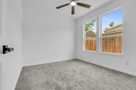 Carpeted empty room with ceiling fan