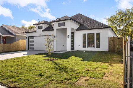 View of front facade featuring a garage and a front lawn