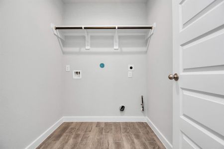 Laundry room, thoughtfully equipped with shelving for effortless organization. Both gas and electric dryer connections available. Sample photo of completed home with similar floor plan. As-built interior colors and selections may vary.