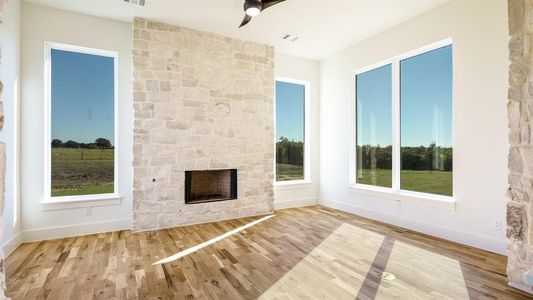 Unfurnished living room with light hardwood / wood-style floors and a stone fireplace