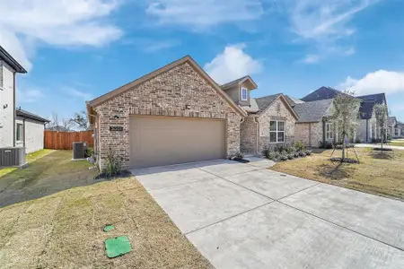 View of front facade with central AC unit, an attached garage, brick siding, fence, and concrete driveway