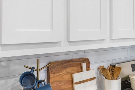 Details featuring light countertops and white cabinets