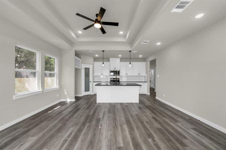 Kitchen featuring hanging light fixtures, dark hardwood / wood-style floors, white cabinetry, and appliances with stainless steel finishes