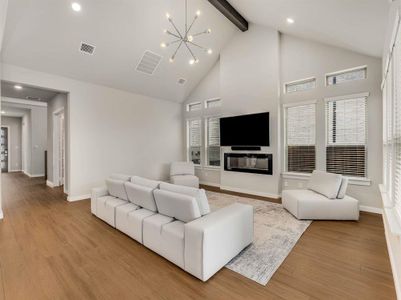 Living room impresses with a modern fireplace, soaring ceilings, and an accent beam