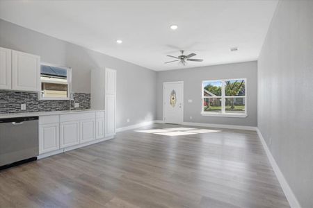 Kitchen with dishwasher, sink, white cabinetry, light hardwood / wood-style flooring, and ceiling fan