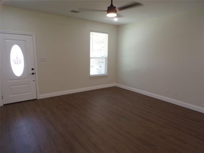 Foyer entrance with ceiling fan and dark wood-type flooring