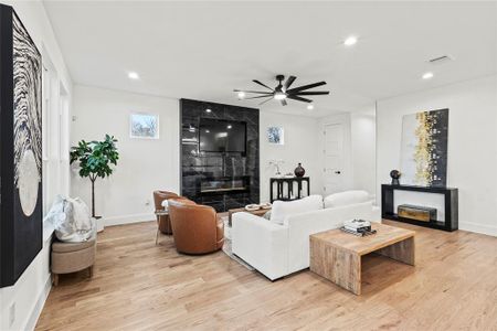 Living area featuring recessed lighting, light wood-style flooring, and a premium fireplace