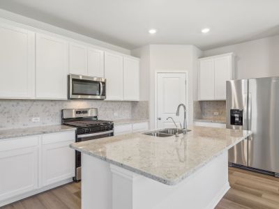 This kitchen features linen-colored cabinets and granite countertops.