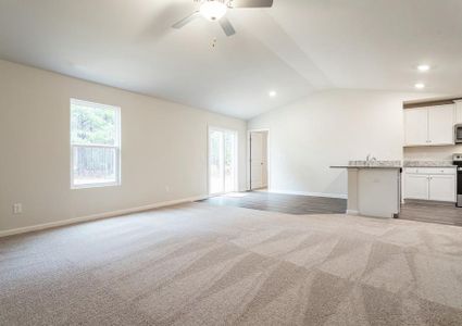 Living room with carpet off the dining nook and kitchen.