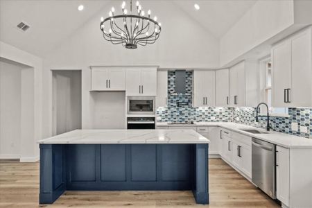 Kitchen with sink, white cabinetry, a center island, stainless steel dishwasher, and black oven