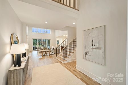 Light-filled, two-story foyer has site lines through the family room onto the charming covered porch.