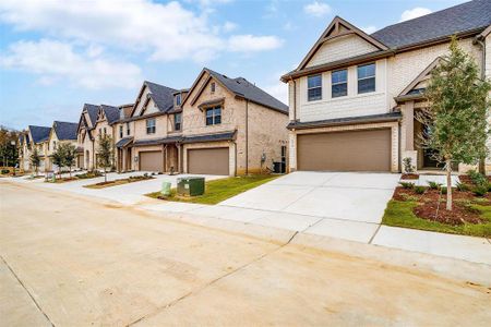 View of front of home with a garage, concrete driveway, central AC unit, and a residential view