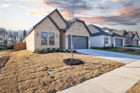 View of front of property featuring a yard and a garage