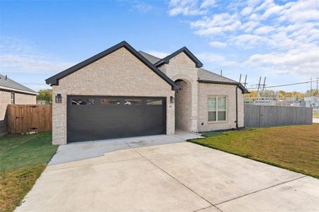 View of front facade featuring a garage and a front lawn