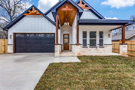 View of front facade featuring a garage, covered porch, and a front lawn