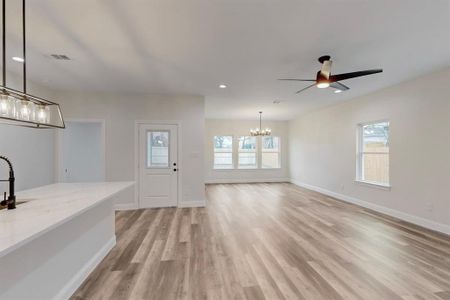 Entrance foyer featuring ceiling fan with notable chandelier and light hardwood / wood-style flooring