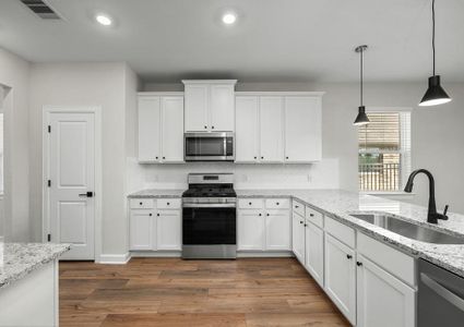 Fully loaded kitchen has white cabinets with hardware.