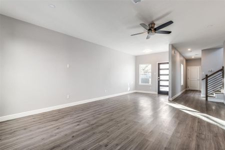 Unfurnished living room featuring dark hardwood / wood-style floors and ceiling fan