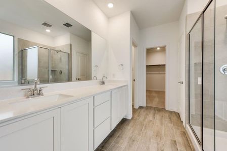 Bathroom with an enclosed shower, wood-type flooring, and vanity