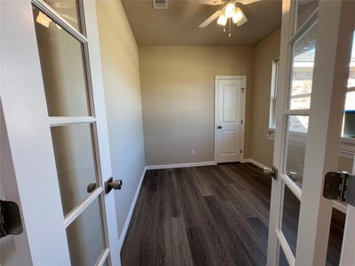 Unfurnished room with dark hardwood / wood-style flooring and french doors