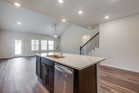 Kitchen featuring dark brown cabinets, dishwasher, dark hardwood / wood-style flooring, an island with sink, and sink