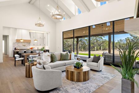 Living area featuring a chandelier, high vaulted ceiling, beamed ceiling, and light wood-style flooring