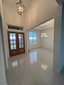 Entryway with french doors and a chandelier