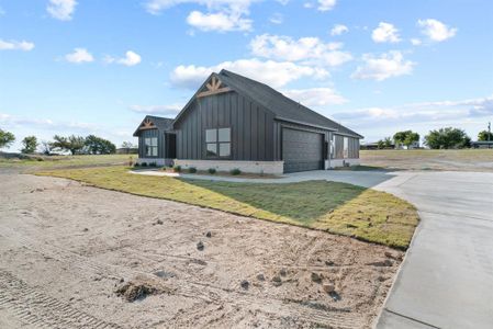 View of property exterior with a yard and a garage