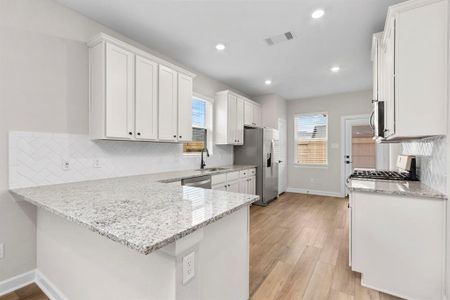 The kitchen has a breakfast bar, granite countertops, and Whirlpool kitchen appliances!